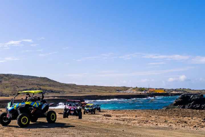 a group of people riding UTVs on a dirt path