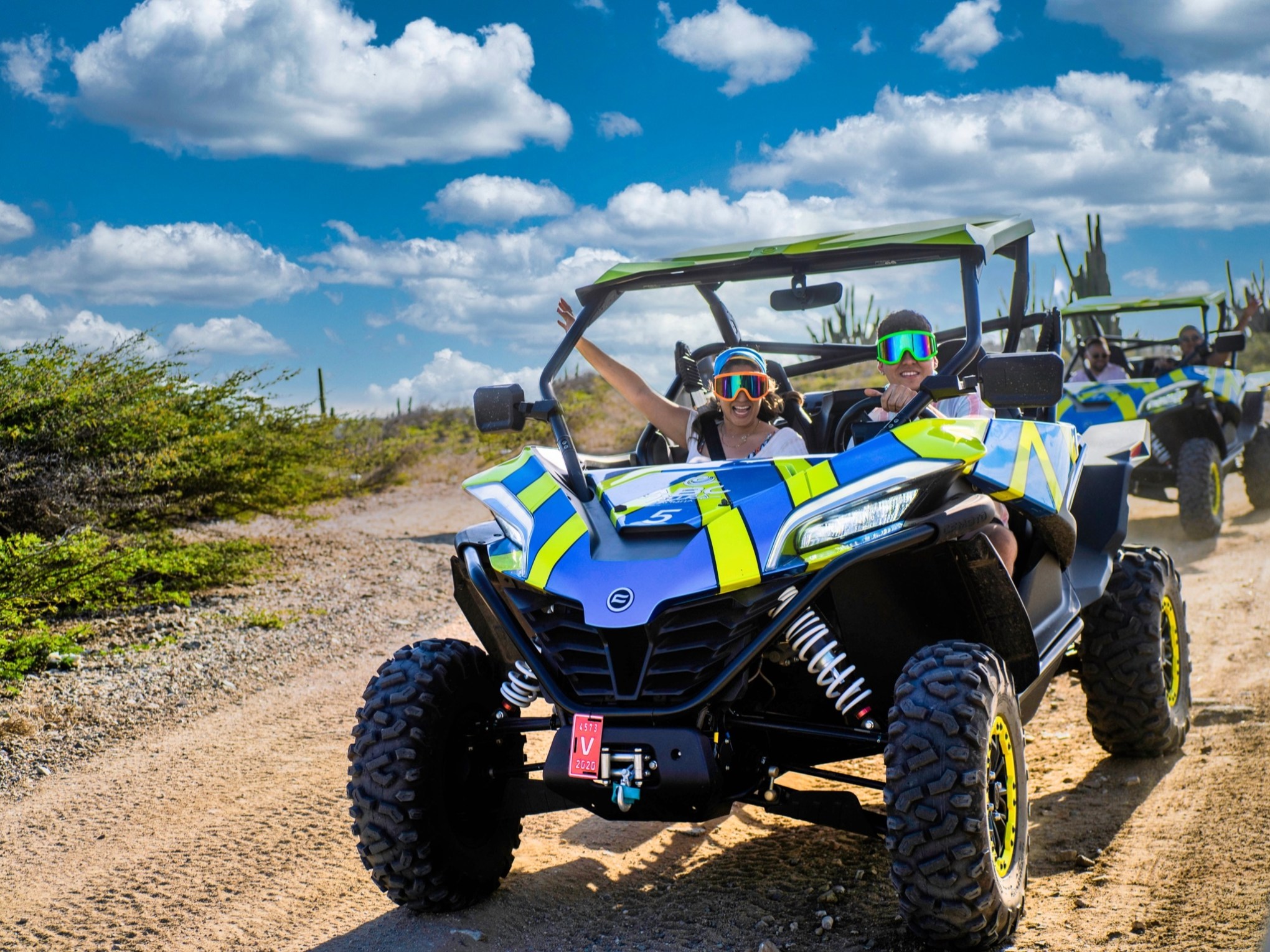 two UTVs going down a dirt path